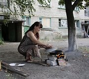 Moteris daugiabučio kieme ruo&scaron;ia maistą.