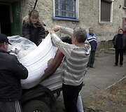 Delbacevo mieste į automobilio priekabą keliami žuvusių žmonių kūnai.