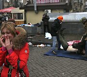 Telefonu kalbančios moters reakcija pamačius kaip Kijeve protestuotojai ne&scaron;a žuvusį kolegą