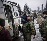 Ukrainos karys ne&scaron;a vaiką į autobusą, kuriuo evakuojami žmonės i&scaron; Debalcevės miesto.