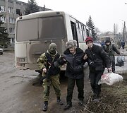Ukrainos karys padeda vyrui pasiekti autobusą, kuriuo evakuojami gyventojai i&scaron; Debalcevės miesto.