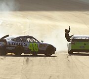 Fini&scaron;avęs Jimmie Johnsonas pozuoja žiūrovams 
