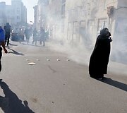 Nuo a&scaron;arinių dujų bėgantys protestuotojai.