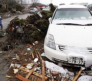 Nuolaužose stovintis apsnigtas automobilis.
