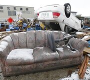 Apsnigta sofa &scaron;alia apvirtusio automobilio Sendajaus mieste.