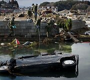 Japonijos kariai prie sugriauto namo