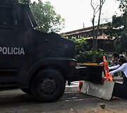 Studentai neleidžia riau&scaron;ių policijos sunkvežimiu pravažiuoti.