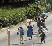 Vietos gyventojai i&scaron;kėlę rankas eina pro Laurento Gbagbo kareivius