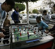 Libijos sostinės gatvėje stalo futbolą žaidžiantys vaikai.