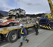 I&scaron;vežami cunamio bangos sulamdyti automobiliai.