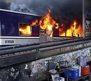 Ugnis veržiasi i&scaron; degančio keleivinio traukino vagono.
