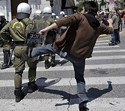Protestuotojas spiria į policininko ne&scaron;amą skydą