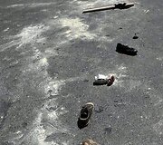 Ant gatvės guli protestuotojų batai ir vėliavos.