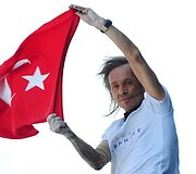 Alainas Robertas užlipęs į ant dangoraižio laiko Turkijos vėliava.