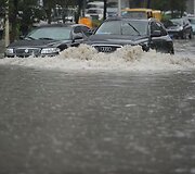 &bdquo;Audi&ldquo; automobilio vairtuojas važiuoja apsemta Vuhano miesto gatve.