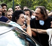 Graikijos įstatymų leidėja Liana Kanelli valosi nuo veido jogurtą, kurį į ją metė protestuotojas.