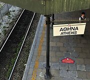 Apsaugos darbuotojas vaik&scaron;to ant tu&scaron;čios platformos pagrindinėje Atėnuose traukinių stotyje.