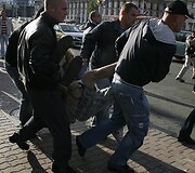 Civilių drabužiais apsirengę milicininkai ne&scaron;a aktyvistą.
