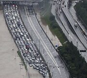 Automobilių spūstis prie apsemto kelio