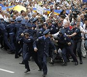Policininkai bėga nuo protestuotojų.