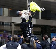 Policininkai sulaiko demonstrantą.