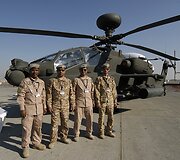 JAE kariai stovi prie AH-64D malūnsparnio
