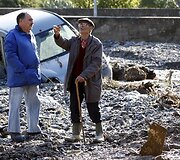 Vyrai kalbasi netoli purvo nuo&scaron;liaužos nuniokoto automobilio.