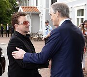 Dainininkas Bono (kairėje) su Norvegijos užsienio reikalų ministru Jonasu Gahru Stoere