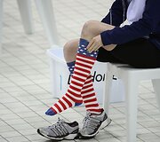JAV plaukikė savo &scaron;alies garbei pasipuo&scaron;ė nacionalinės vėliavos motyvais i&scaron;margintomis kojinėmis.