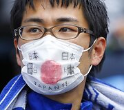 Japonai su kaukėmis nesiskiria net olimpiniame stadione. Tiesa, &scaron;įkart kaukės tikslas kitas &ndash; ji virto &scaron;alies vėliavos imitacija.