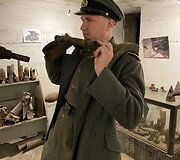 Aivaras Kurskis demonstruoja, kaip kariai užsidėdavo kulkosvaidžio pečių atramą