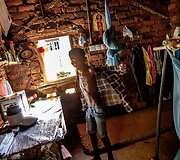 Samudhita prie darbo stalo, kuris atstoja kartu ir tualeto staliuką. De&scaron;inėje kampe - drabužinė. 