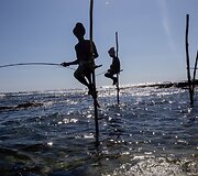 Ant stiebų sėdintys netikri žvejai už pinigus pozuojantys turistams