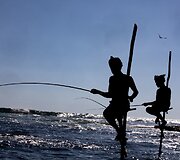 Ant stiebų sėdintys netikri žvejai už pinigus pozuojantys turistams