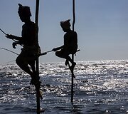 Ant stiebų sėdintys netikri žvejai už pinigus pozuojantys turistams