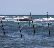 Ant stiebų sėdintys netikri žvejai už pinigus pozuojantys turistams