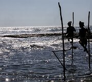 Ant stiebų sėdintys netikri žvejai už pinigus pozuojantys turistams