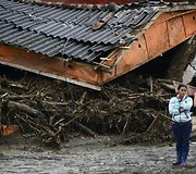 Žmonės &scaron;alia purvo nuo&scaron;liaužos sugriauto namo Kolumbijoje