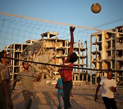 Palestiniečiai žaidžia tinklinį prie sugriautų namų