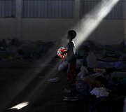 Nelegaliai laivu į Indoneziją patekusių pabėgelių berniukas žaidžia kamuoliu prieglaudoje