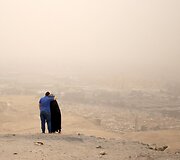 Apsikabinusi pora ant kalvos žvelgia į miglotą Kairo peizažą
