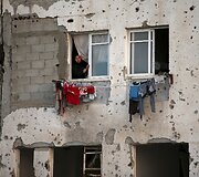 Palestinietė žvelgia pro savo namų langą