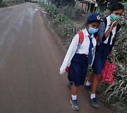 Kelionė į mokyklą Indonezijoje su kaukėmis nuo vulkaninių pelenų
