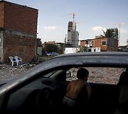 Vaikas ma&scaron;inoje žvelgia į griaunamus namus Brazilijoje pasiruo&scaron;iant 2016 metų Olimpinėms žaidynėms