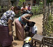 Myint Naing rituali&scaron;kai nuplaunamas nuo piktųjų dvasių prie&scaron; įžengiant į namus