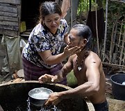 Myint Naing rituali&scaron;kai nuplaunamas nuo piktųjų dvasių prie&scaron; įžengiant į namus