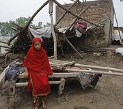 Pakistaniečių mergaitė prie potvynio sugriautų savo namų