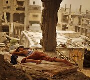 Palestinietis berniukas miega ant čiužinio savo sugriautuose namuose