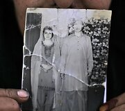 Allah Rakhi, kuriai nosį ir dalį pėdos nurėžė vyras laiko savo vestuvių nuotrauką