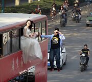 Magas ir jo asistentė kybo prie autobuso